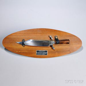 Reproduction c. 1830 Bowie Knife, Carvel Hall Company, 20th century, embossed plaque with explanatory text, all mounted to oval wood pa