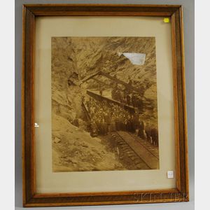 Oak Framed Photography of Figures at an Iron Railroad Bridge through a Rock Pass