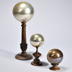 Three Gilt Glass Spheres, late 19th century, each mounted to a turned base, ht. to 18 in.