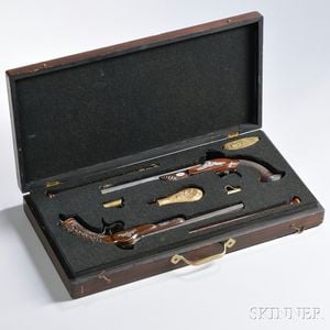 Cased Set of French Target Pistols, c. mid-19th century, a dueling pistol with ornate foliate carvings on the stock, marked on the lock