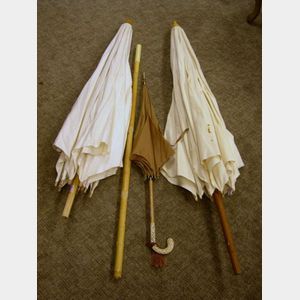 Two Early 20th Century Linen Beach Umbrellas and a Faux Ivory Handled Rain Parasol.