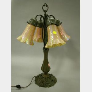 Patinated Cast Iron Table Lamp with Four Iridescent Art Glass Sconce Shades.