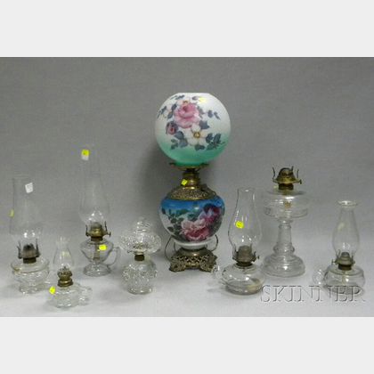 Seven Colorless Pressed Glass Kerosene Lamps and a Rose-decorated Glass and Brass Kerosene Gone-with-the-wind Table Lamp