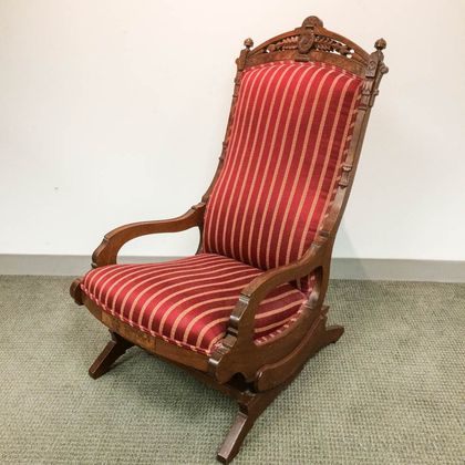 Renaissance Revival Carved and Upholstered Walnut Platform Armed Rocking Chair. Estimate $200-250
