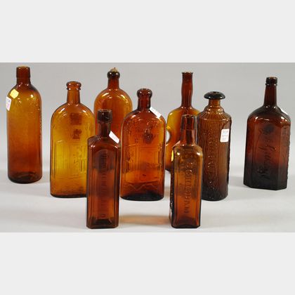 Nine Assorted Amber Pressed Glass Bottles