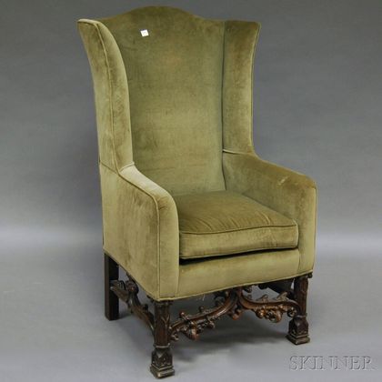 Gothic Revival-style Upholstered Carved Walnut Wing Chair. Estimate $800-1,200