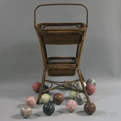 Fifteen Victorian Porcelain Carpet Balls Displayed on a Two-tier Woven Rattan Stand. Estimate $300-500