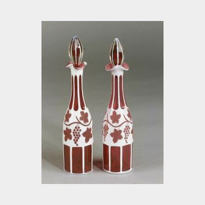 Near Pair of Bohemian Cranberry, Clear Cased, and White Flashed Cut Glass Decanters