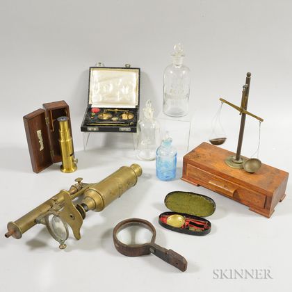 Three Glass Apothecary Bottles, Two Microscopes, a Portable Scale, and a Magnifying Glass. Estimate $200-300