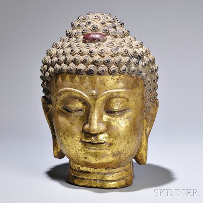Cast Iron Buddha Head, China, the gilt face with downcast eyes and smiling lips, ht. 15 1/8 in. 