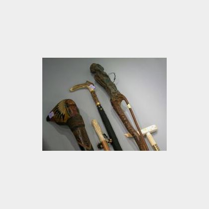 Collection of Five Carved Wood, Ivory, and Antler Clubs, Canes, and an Umbrella. 