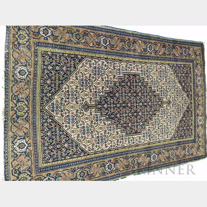 Senneh Rug, Northwest Persia, early 20th century, featuring a navy stepped and pendanted diamond-shaped center medallion on an ivory fi