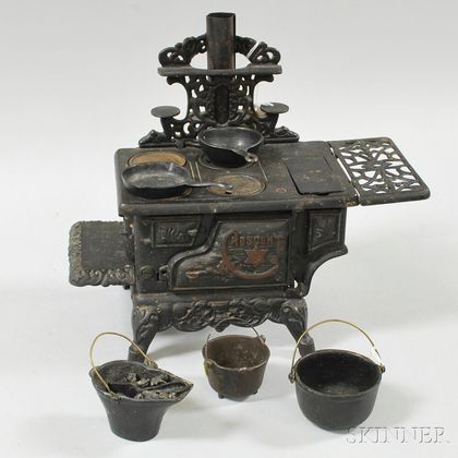 Sold at Auction: Two Miniature Cast Iron Stoves and Pans