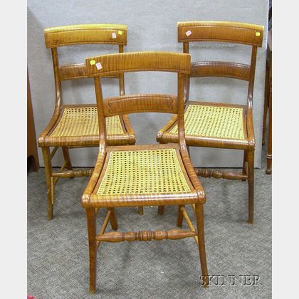 Three Classical Carved Tiger Maple Side Chairs with Caned Seats. 