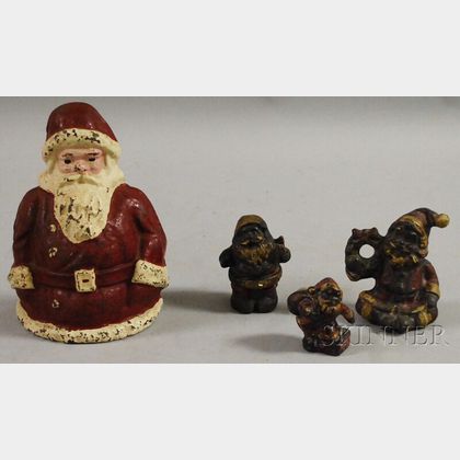 Four Painted Cast Iron Santa Claus Figural Doorstops and Paperweights