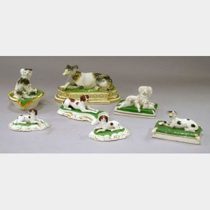 Seven Assorted Small English and Continental Ceramic Reclining Dog Figurals