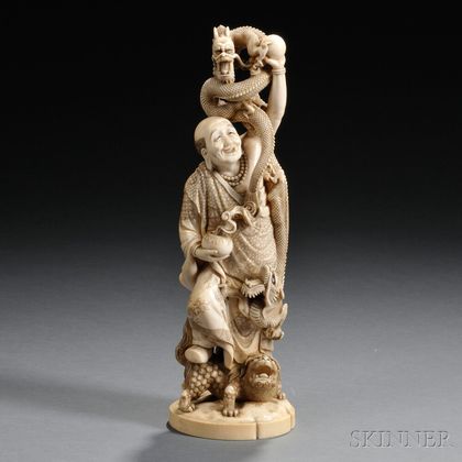 Ivory Okimono of a Man with Dragons and a Lion