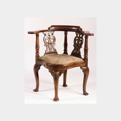 Mid-Georgian Walnut Corner Chair, 18th century, with U-shaped arms and owls-eye splats, slip seat and shell carved cabriole legs endin 