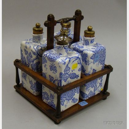 Set of Four British Late Victorian Transfer Decorated Ceramic Liquor Decanters in an Oak Stand