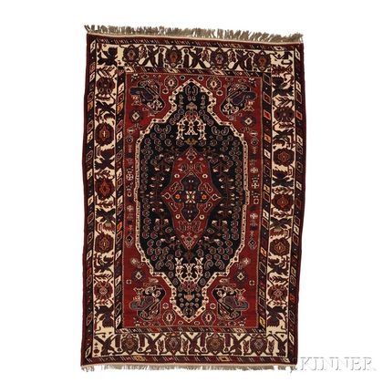 Shirvan Rug, East Caucasus, c. 1910, the large deep aubergine lozenge inset with a blue/aubergine cruciform device in a red medallion f