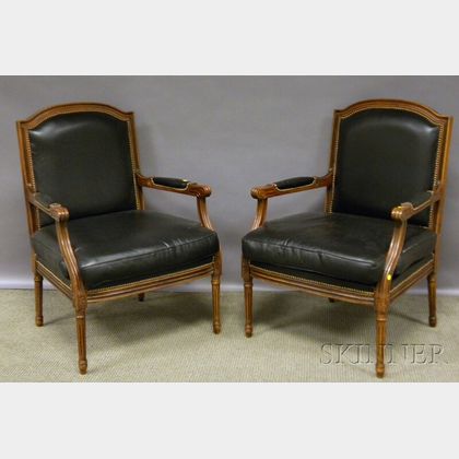 Pair of Chateau DAx Louis XVI-style Black Leather Upholstered Carved Walnut Fauteuil. 