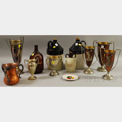 Seven Early 20th Century Metal Trophy Cups, Two Stoneware Jugs, an Advertising Dish, Amber Glass Liquor Flask, and Stoneware Jug
