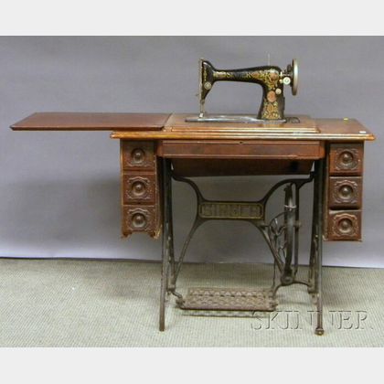 Singer Victorian Treadle-powered Sewing Machine with Walnut Cabinet. 