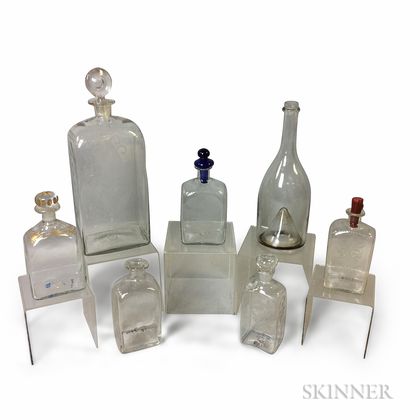 Seven Colorless Blown Glass Bottles and Decanters